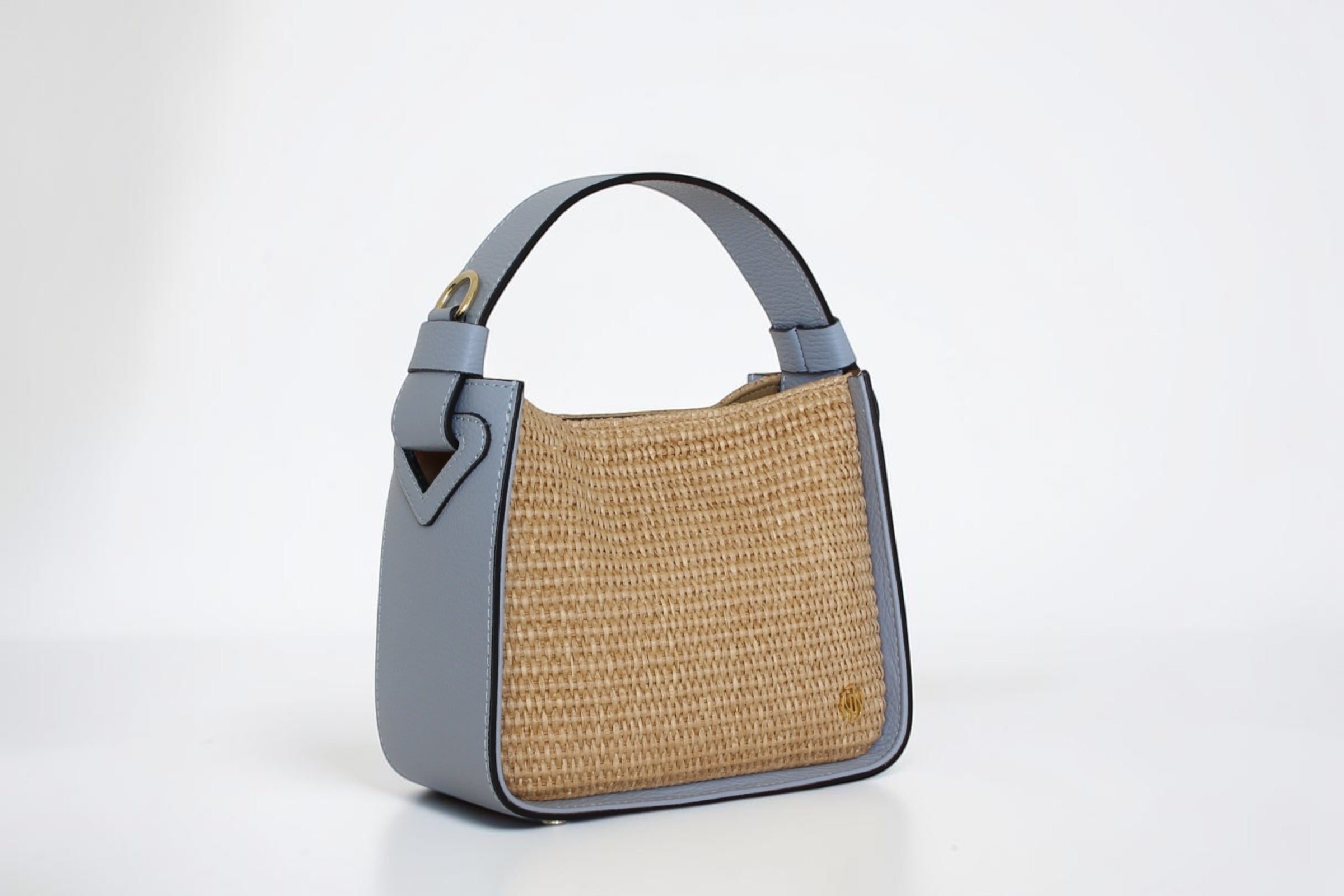 Affinée Élan Sea handbag, three-quarter view showing the woven panel and leather side