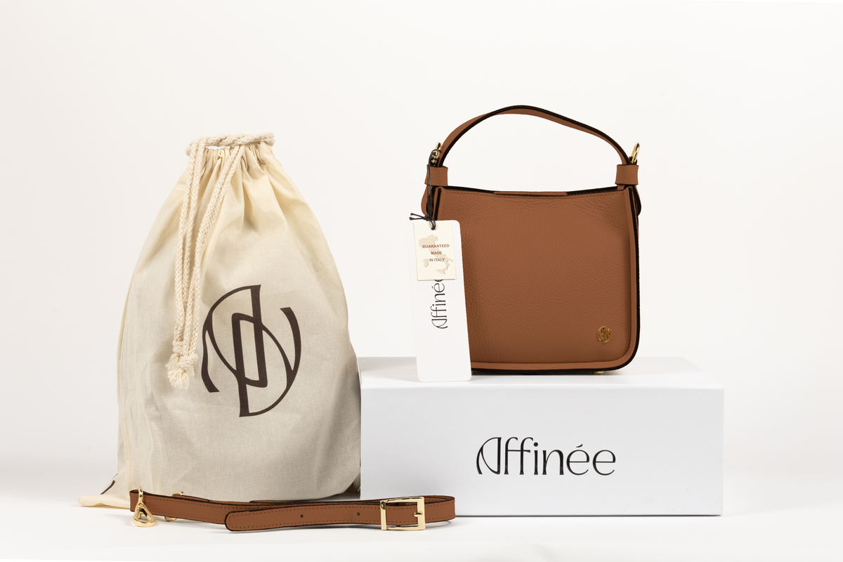 Affinée Élan Caramel handbag, packaging display with dust bag, product card and shoulder strap